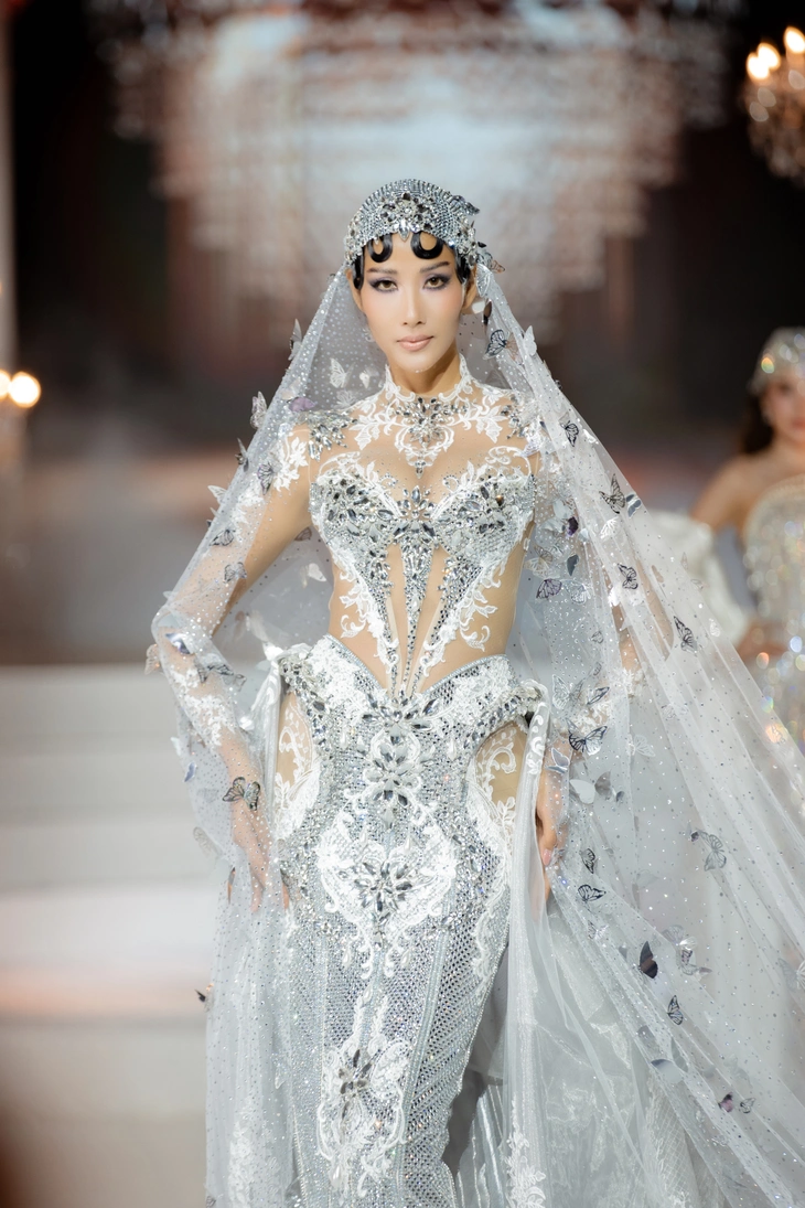 Hoàng Thùy diện thiết kế đính kết thủ công từ các loại đá swarovski kết hợp Juliet Cap hoàn thiện tỉ mỉ với phần choàng được đính kết bướm 3D đẹp mắt.